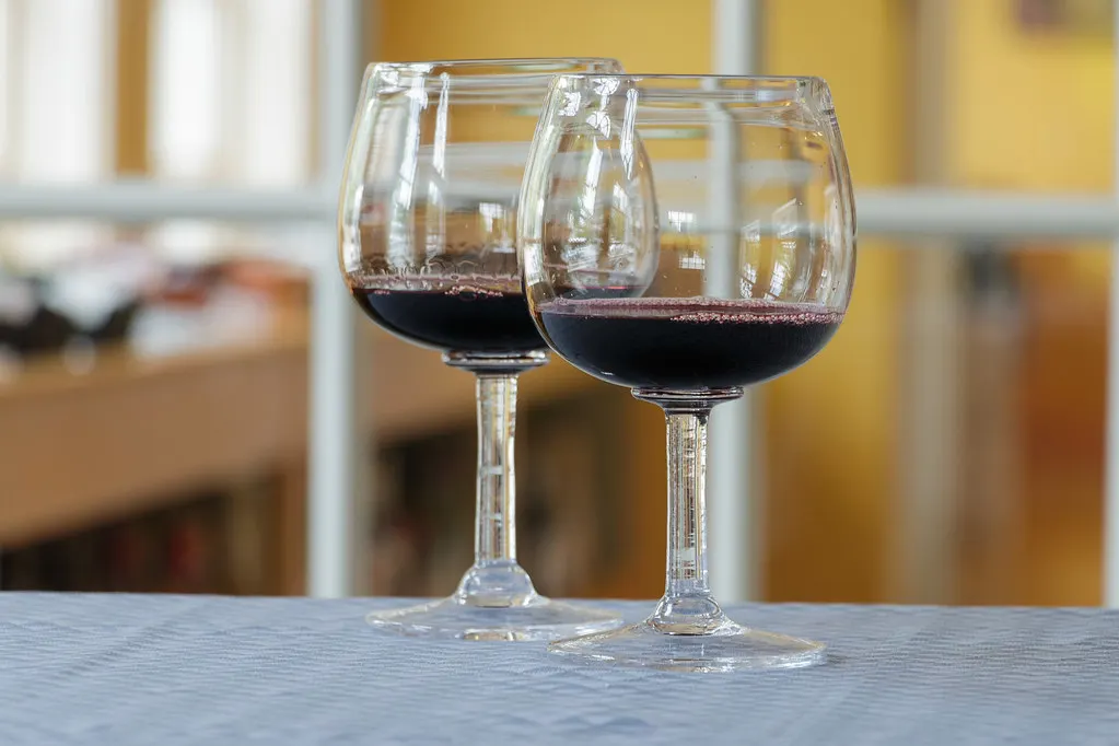 Două pahare de vin roșu, pe o masă