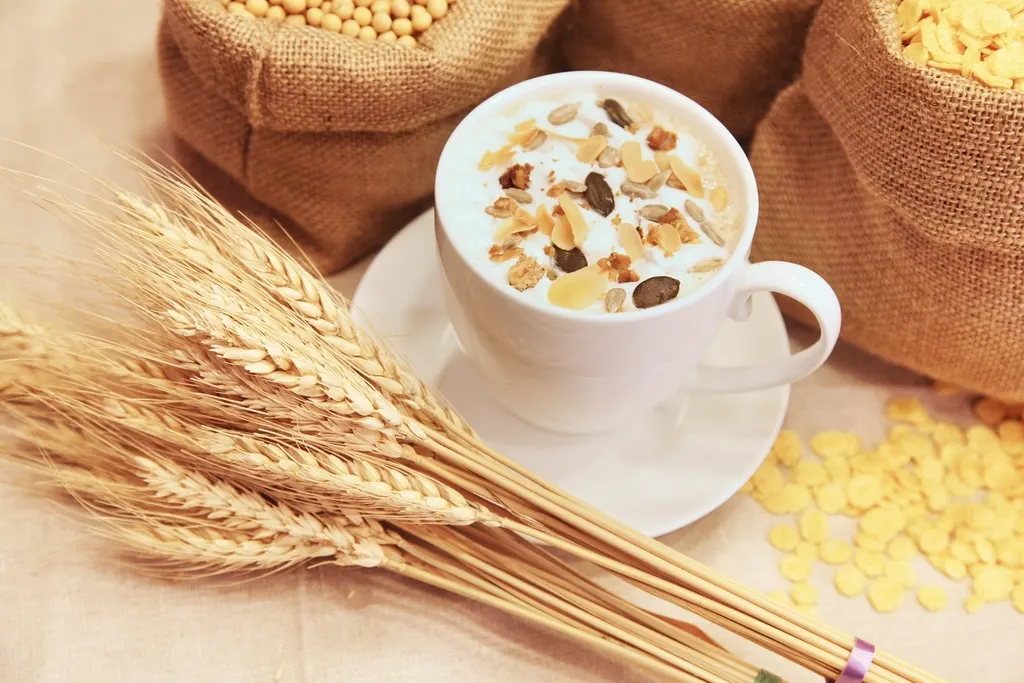 O ceașcă de iaurt cu cereale, lângă spice de grâu